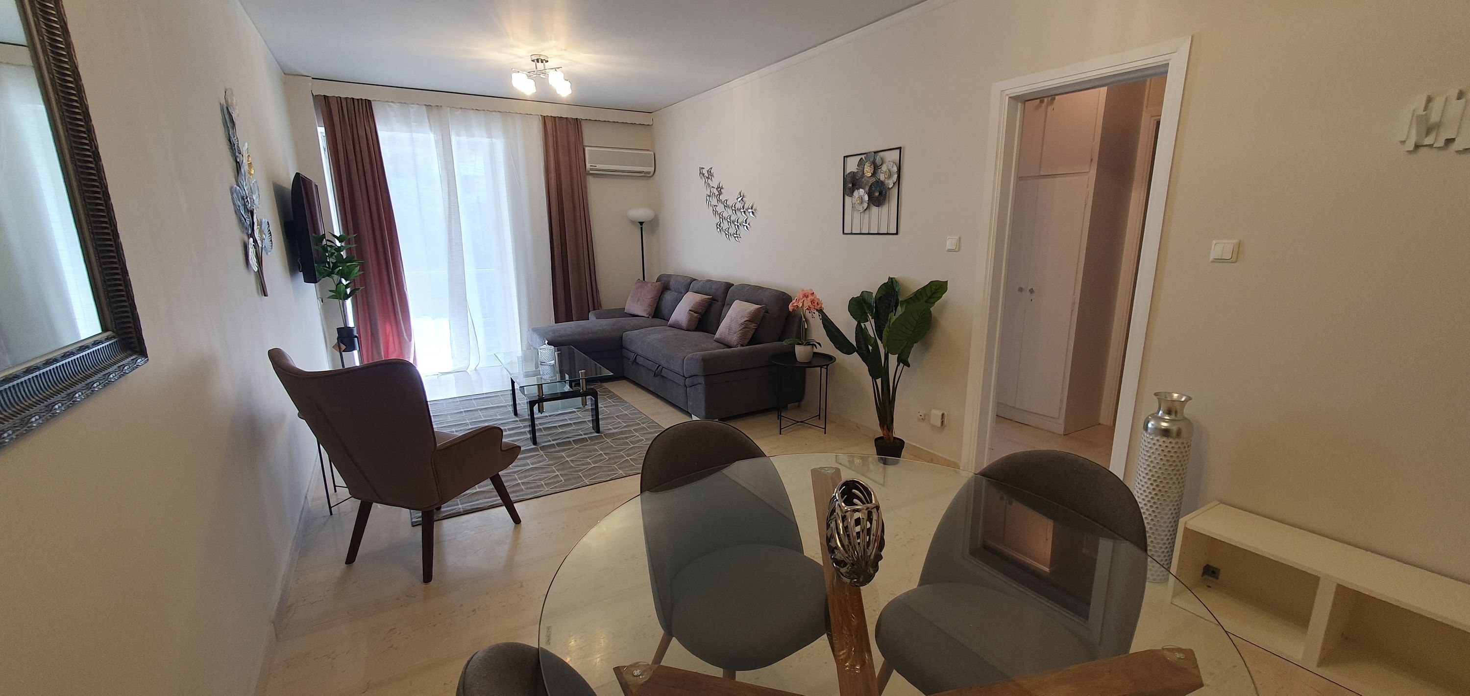 Een moderne woonkamer met een bank, stoelen, een salontafel en een eethoek met een tafel en stoelen.