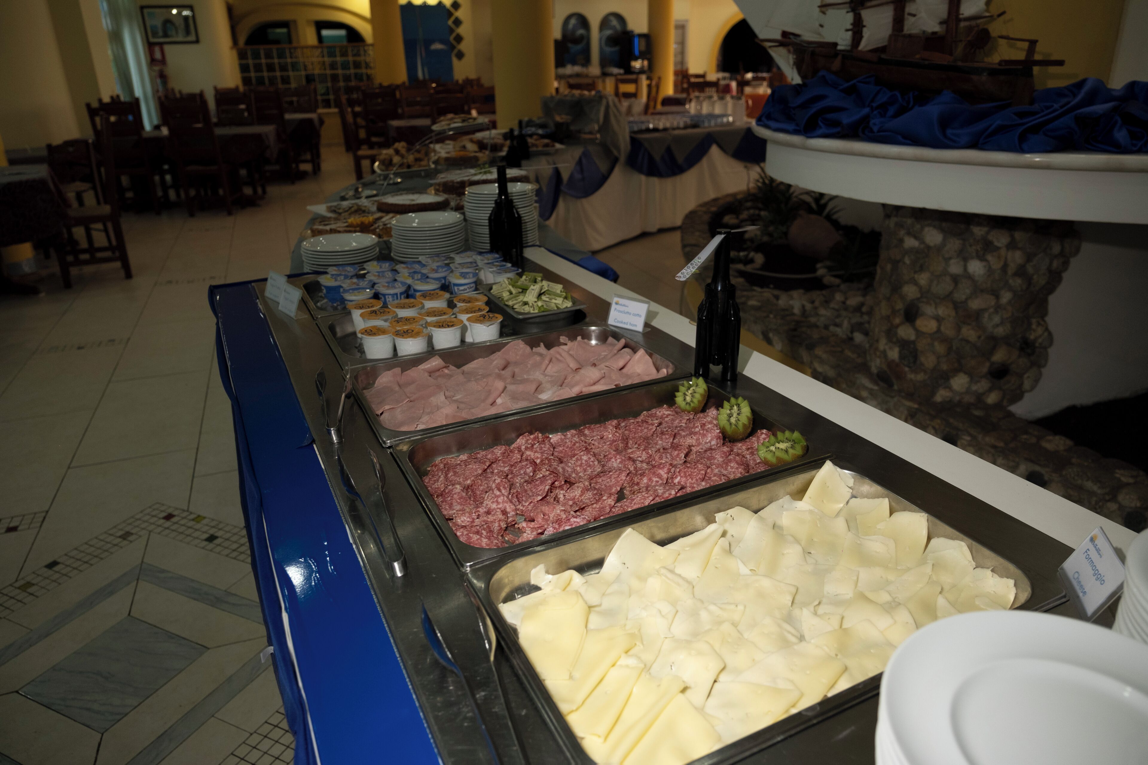 A buffet with various food options including meats, cheeses, and salads.