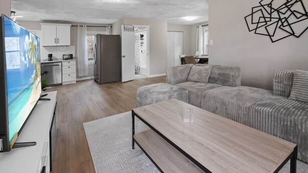 Ein modernes Wohnzimmer mit einer Couch, einem Couchtisch und einem Fernseher.