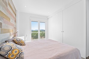 Un dormitorio con cama, ventana con vistas y armario.
