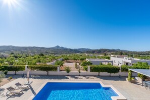 A swimming pool with a view of a landscaped garden and distant mountains. - Apartment 'Unforgettable Rental in A Beautiful' with Balcony, Wi-Fi and Air Conditioning (Macisvenda)