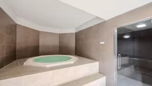 Ein modernes Badezimmer mit freistehender Badewanne, einer Duschkabine aus Glas und einer gewölbten Decke.