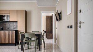 Eine moderne Küche mit Essbereich, einem an der Wand befestigten Fernseher und einer Tür mit Schloss.