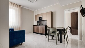 Eine moderne Wohnung mit Küche, Essbereich und einem blauen Sofa.