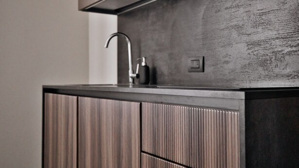 Eine moderne Küche mit integriertem Spülbecken, Armatur aus Edelstahl und Holzschränken.