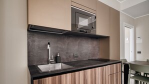 Eine moderne Küche mit eingebauter Mikrowelle, einem Spülbecken und Holzschränken.
