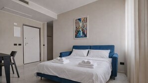 Ein modernes Hotelzimmer mit einem großen Bett, einem Schreibtisch und einem Bild an der Wand.