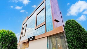A modern hotel building with a prominent sign reading 'HOTEL SINGHANIA PREMIER.' - Super Hotel O Raipur (Raipur)