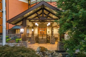 A hotel entrance with a covered porch, stone pillars, and a wooden gate. - 🏔 Baskins Creek 502 - Cozy Condo Steps from Downtown | Private Balcony🏔 (Gatlinburg)