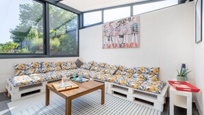 Un salon moderne avec un canapé, une table basse et des œuvres d’art accrochées au mur.