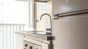 A kitchen with a stainless steel sink, a built-in oven, and a refrigerator. - Fiera Milano - Total Relax Pero is a cozy and functional apartment, ideal for those seeking tranquility and comfort.Located just minutes from Fiera Milano Rho and well connected to the center of Milan, it offers well-kept rooms, equipped kitchen and comf (Pero)