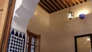 Un dormitorio con una cama, un armario de madera, un espejo y una pared con diseño.