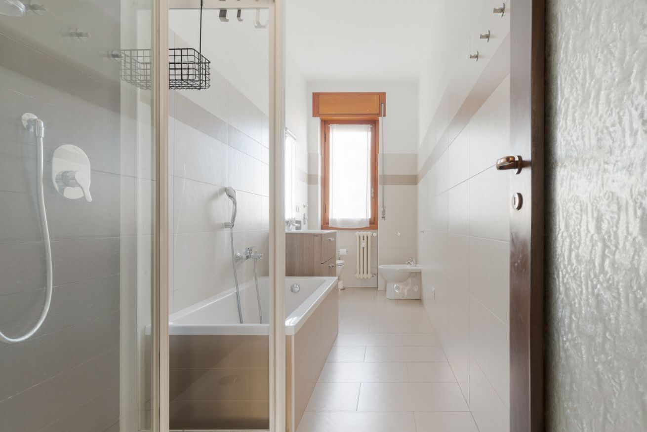 Een moderne badkamer met een douchecabine van glas, een badkuip, een toilet en een bidet.