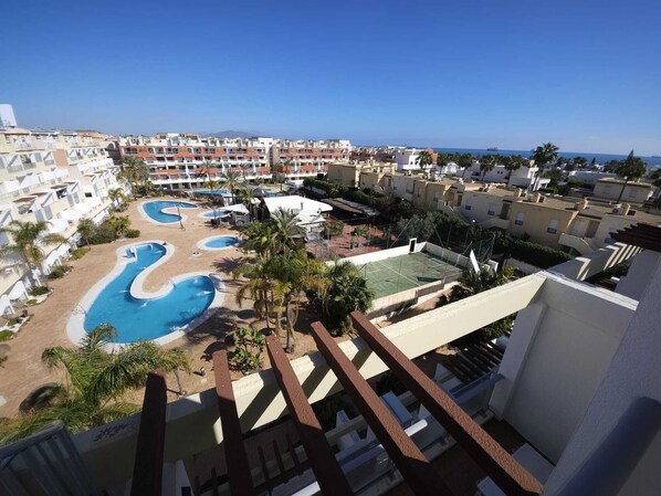 A resort with multiple swimming pools, a tennis court, and a view of the sea. - Penthouse with ocean view, sun deck, and private parking space (Vera)