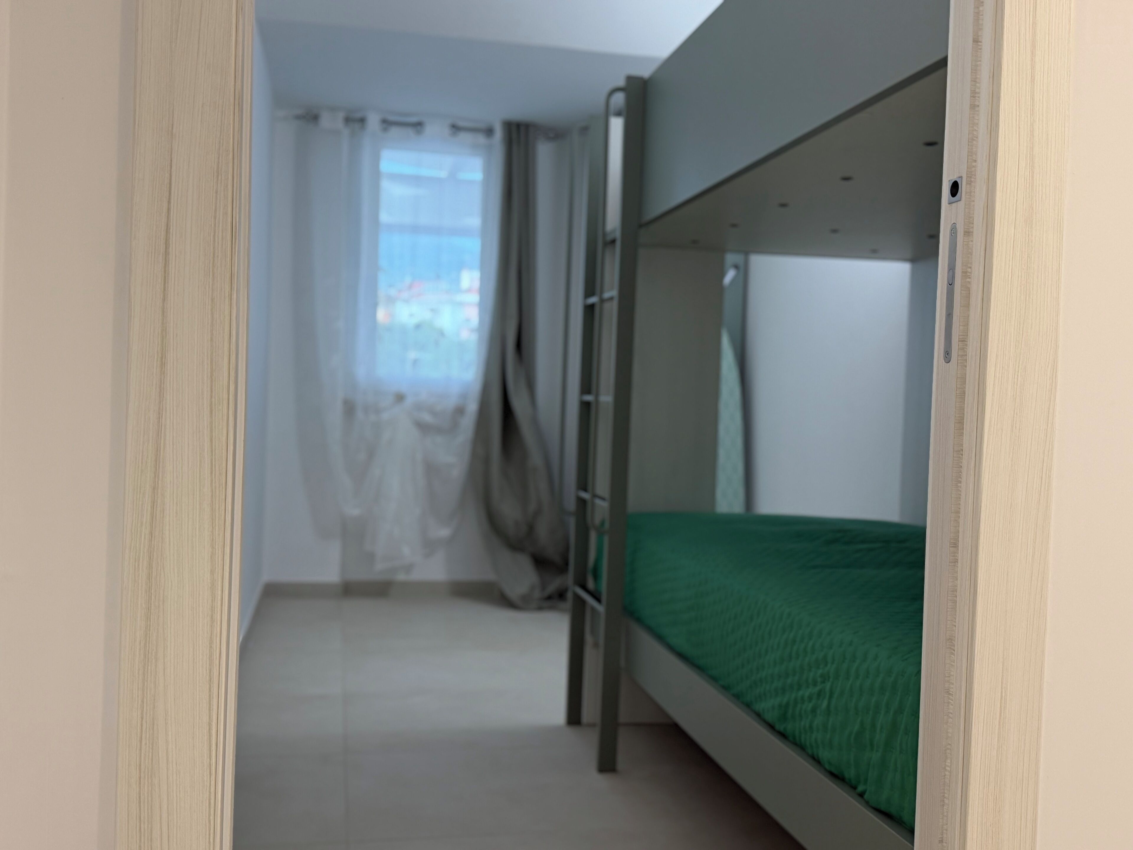 Une chambre avec des lits superposés offrant une vue sur la ville par la fenêtre.