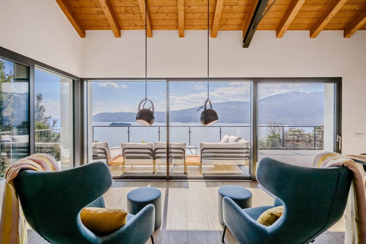 Ein modernes Interieur mit einem Balkon mit Blick auf eine gebirgige Landschaft.