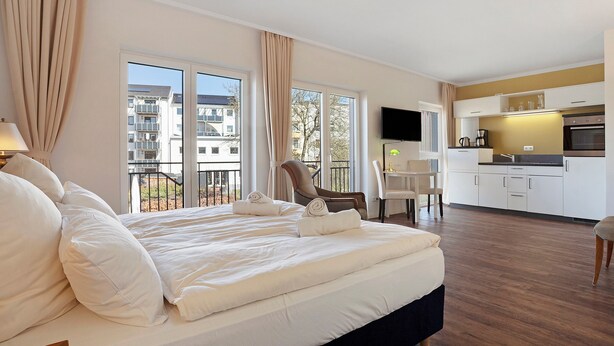 Un dormitorio con una cama grande, un comedor y una cocina.