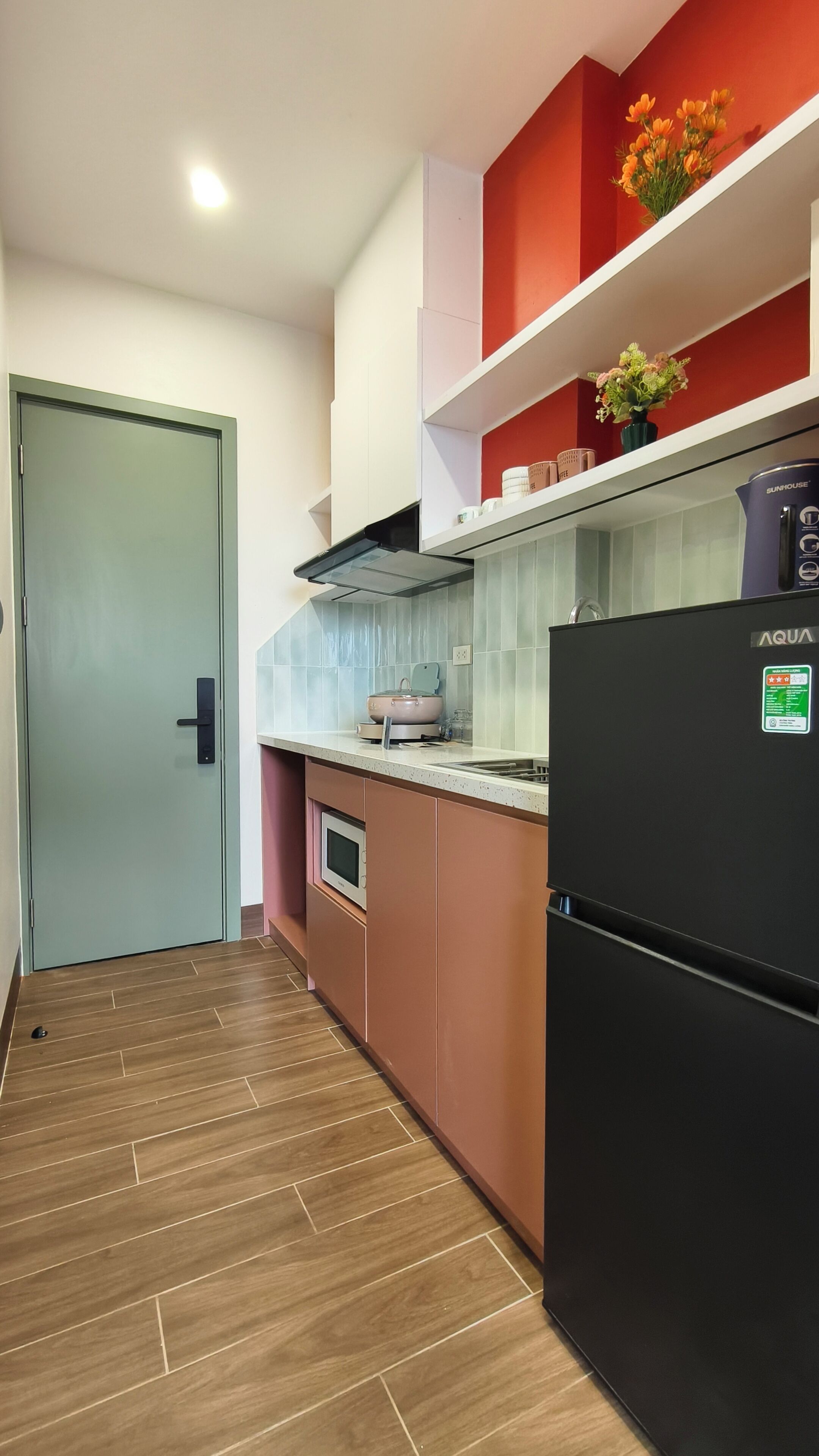 A compact kitchen with a refrigerator, oven, and microwave.
