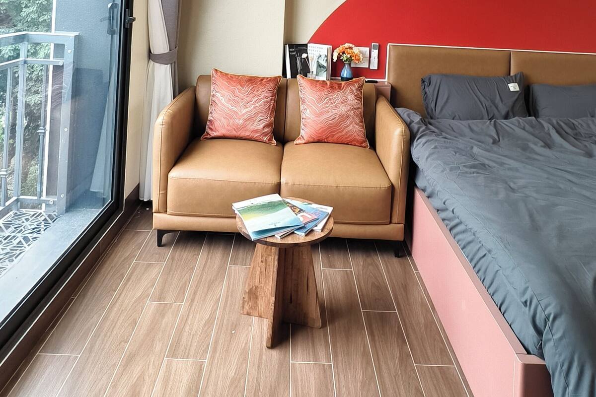 Une chambre d’hôtel moderne équipée d’un canapé, d’un lit, d’une table basse et d’une grande fenêtre.