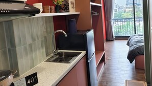 A modern kitchen with a built-in oven, a sink, and a refrigerator. There is a balcony with a view of the city. - Klara House Phuc Dong (Hanoi)