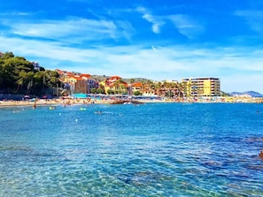 A coastal town with a beach, buildings, and clear blue water. - Cozy apartment "La Piazzetta"  in a building with a garden and swimming pool. (Civezza)
