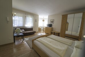 A bedroom with a bed, a desk, a sofa, and a wardrobe. - 741A Gwürzerhof Apartment (Termeno sulla strada del vino)