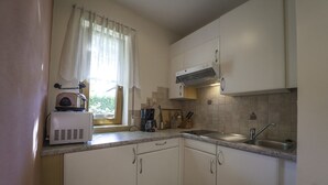 A compact kitchen with a toaster, coffee maker, and a sink.