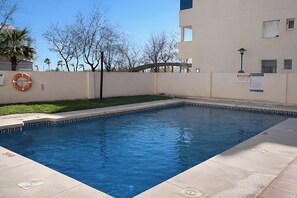 A swimming pool with a lifebuoy, a sign, and a lamp post. - Albaida Sun Terrace (El Morche)