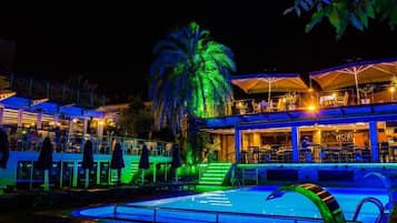 Una piscina techada, una piscina al aire libre de temporada, sombrillas