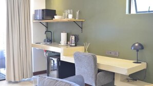 A compact room with a kitchenette, a desk, and a chair. - Misasa on Orchard - Quarto Duplo Deluxe com Varanda 2 (Cape Town)