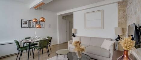 Un salon moderne comprenant un coin repas, un canapé, une table basse et une cheminée.