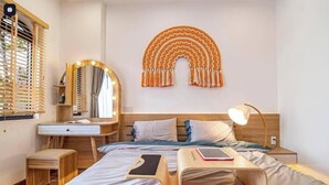 Un dormitorio moderno con cama, mesita de noche, lámpara y un adorno en la pared.