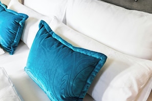 A bed with white bedding and teal pillows. - Motel One Koblenz (Koblenz)