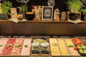 A buffet with various food options including meats, cheeses, and vegetables. - Motel One Koblenz (Koblenz)