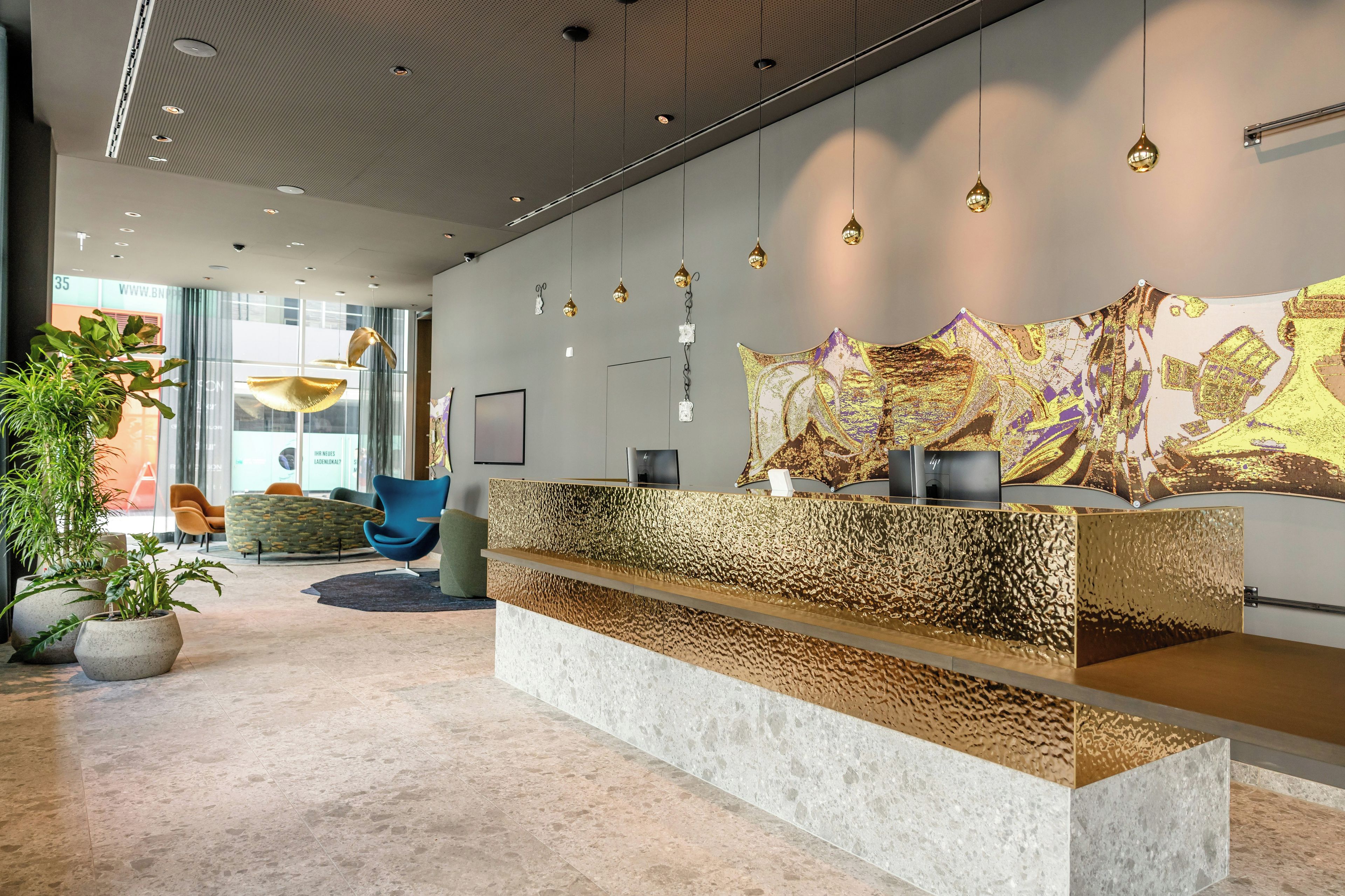 A reception area with a modern design, featuring a reception desk, seating area, and a large abstract painting on the wall.
