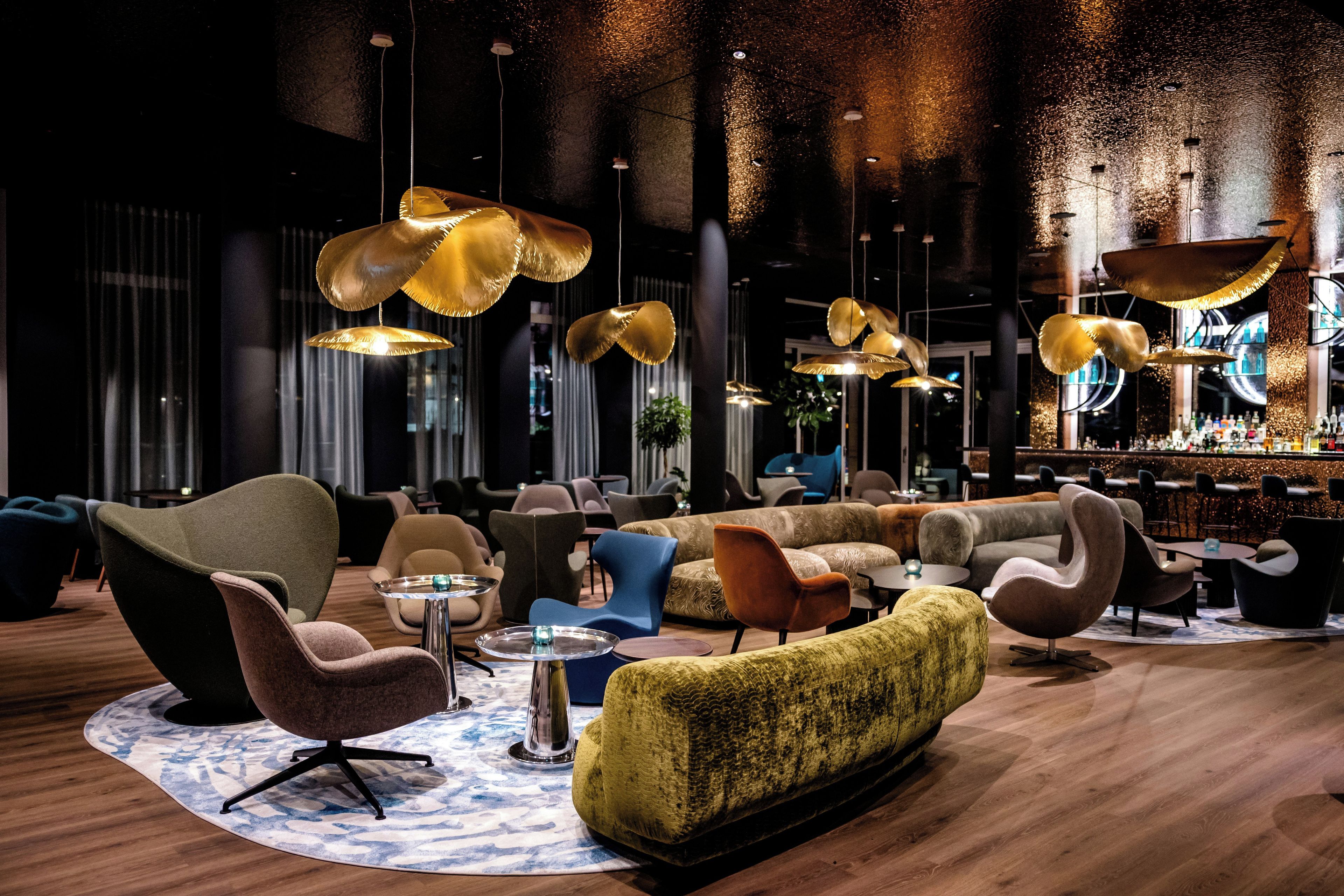 A modern lounge area with sofas, chairs, and a bar.