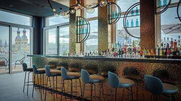 A bar area with multiple stools and a variety of bottles.