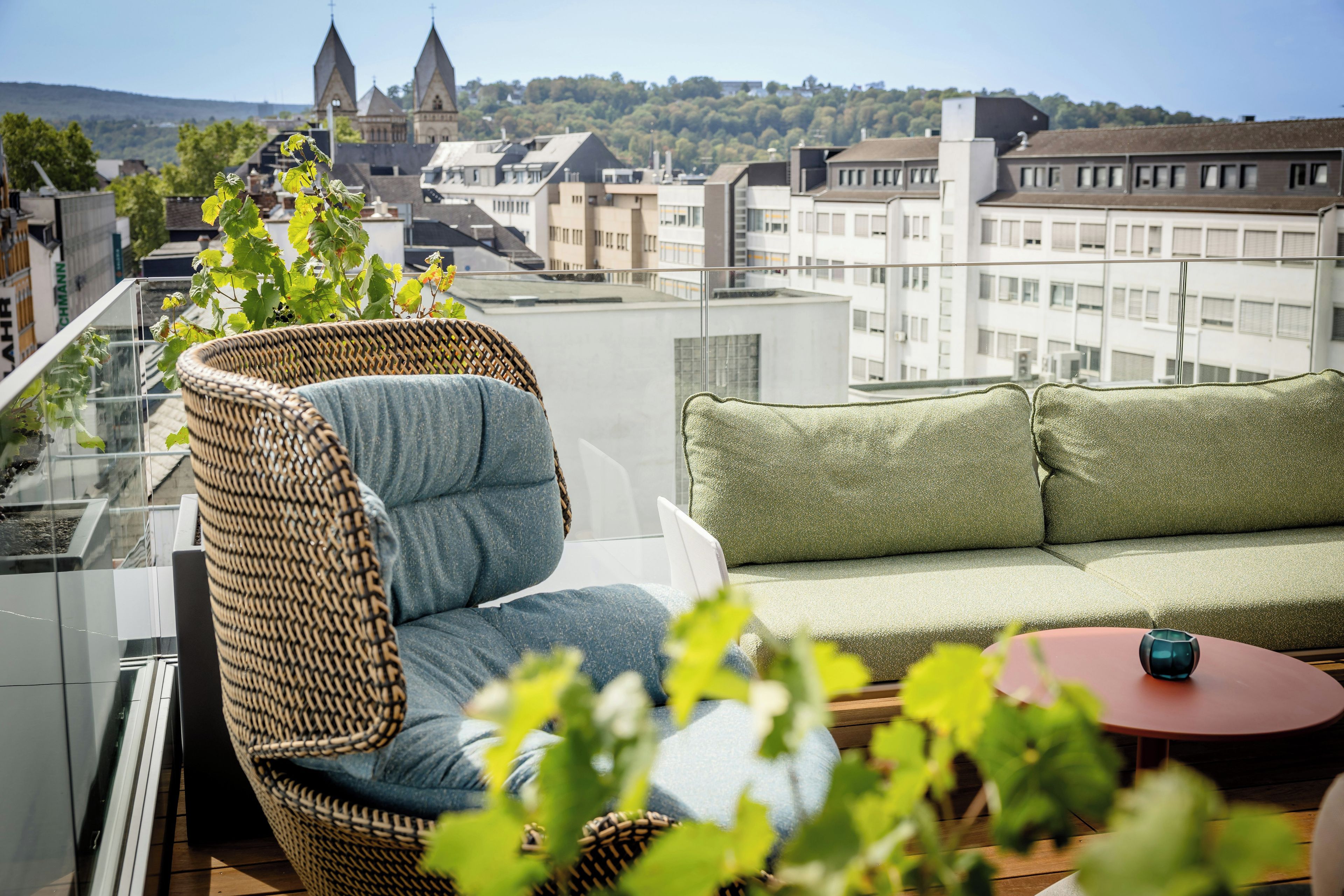 Un balcon agrémenté de meubles en osier, d’un canapé moelleux et d’une petite table.