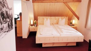 A wooden-framed bedroom with a bed, two bedside tables, and a nightstand. - Hotel Pension Löwen nahe Feldkirch - günstige Zimmer für Urlauber, Firmen und Monteure (Sulz)