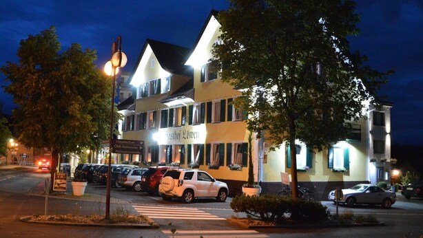 A multi-story building with a sign reading 'Gasthof Löwen' and a street view with parked cars and a crosswalk. - Hotel Pension Löwen nahe Feldkirch - günstige Zimmer für Urlauber, Firmen und Monteure (Sulz)
