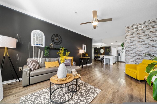Un salon moderne avec un canapé, une table basse et un fauteuil jaune.