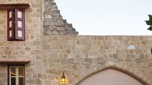 A stone building with a pool, a bench, and a lamp. - Vivila in the medieval city of Rhodes (Rodos)