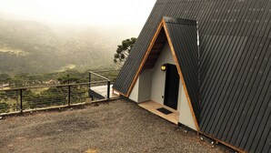 Un bâtiment moderne doté d’un toit en pente, d’une petite entrée et d’un sol recouvert de gravier.