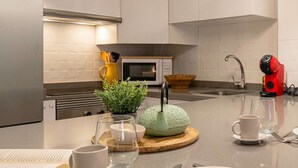 A modern kitchen with a microwave, sink, and a red coffee machine. - Casares Rooftop Apartment by Costarentals (Casares)