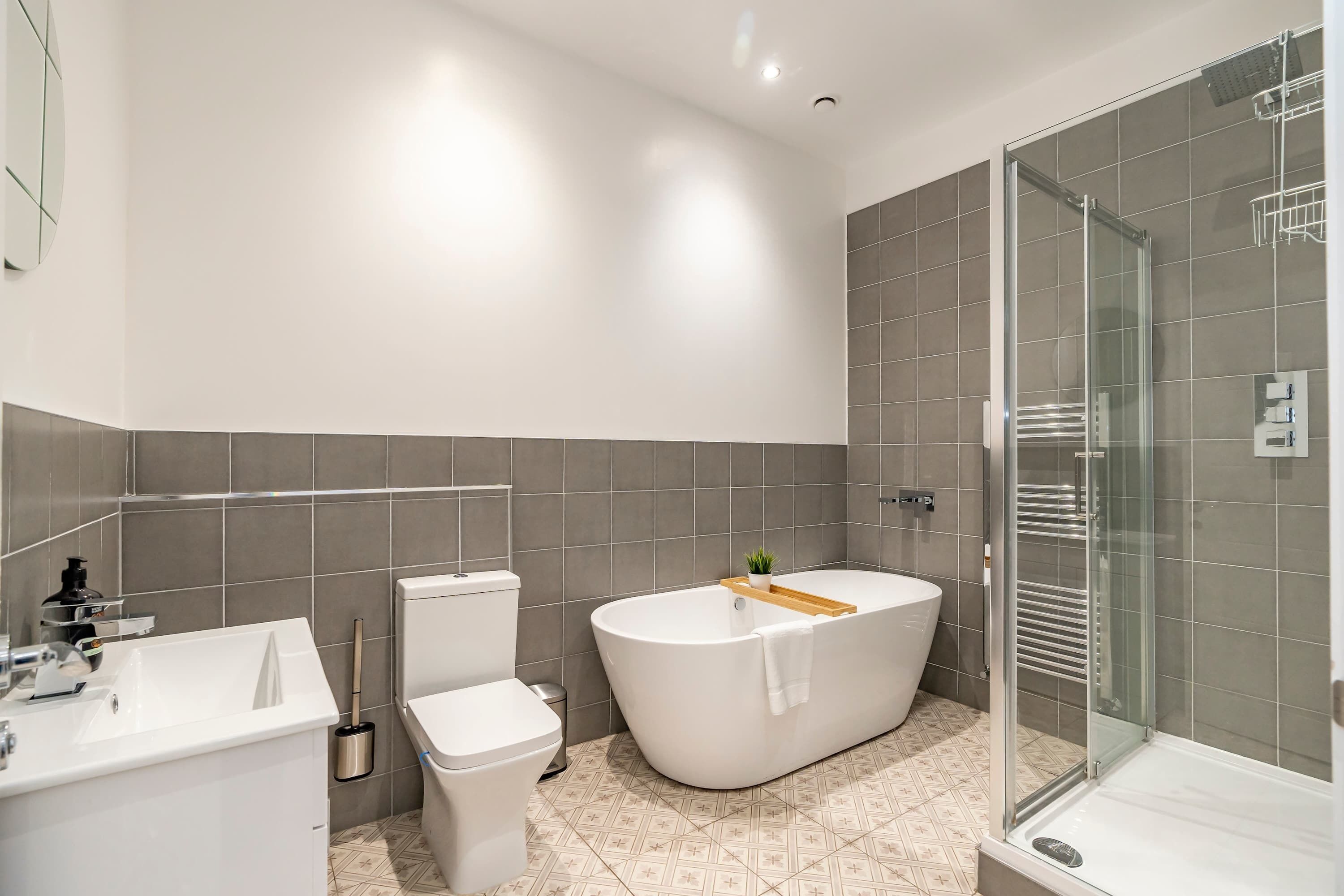 A modern bathroom with a freestanding bathtub, a toilet, and a glass-enclosed shower area.