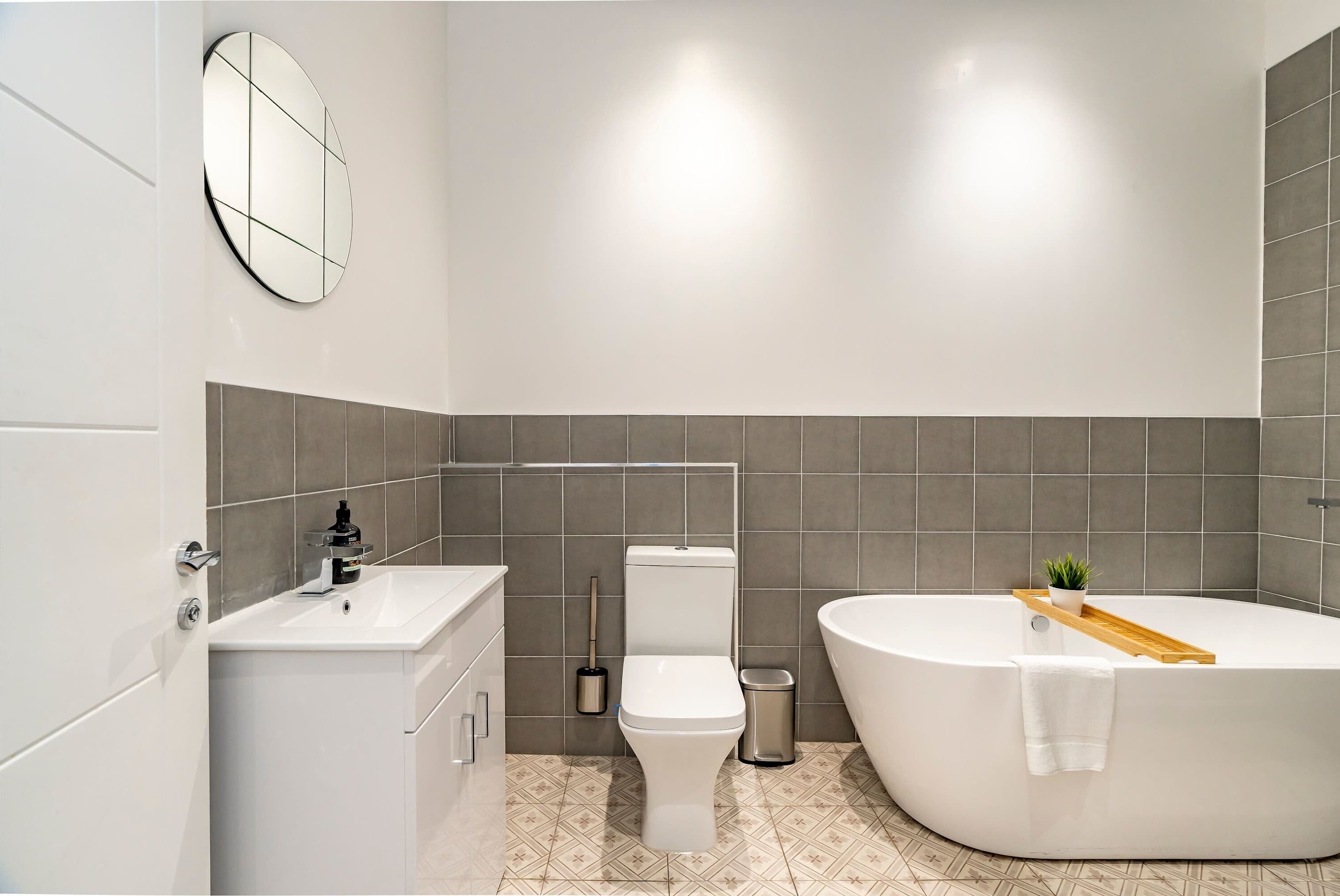 A modern bathroom with a toilet, sink, and bathtub.
