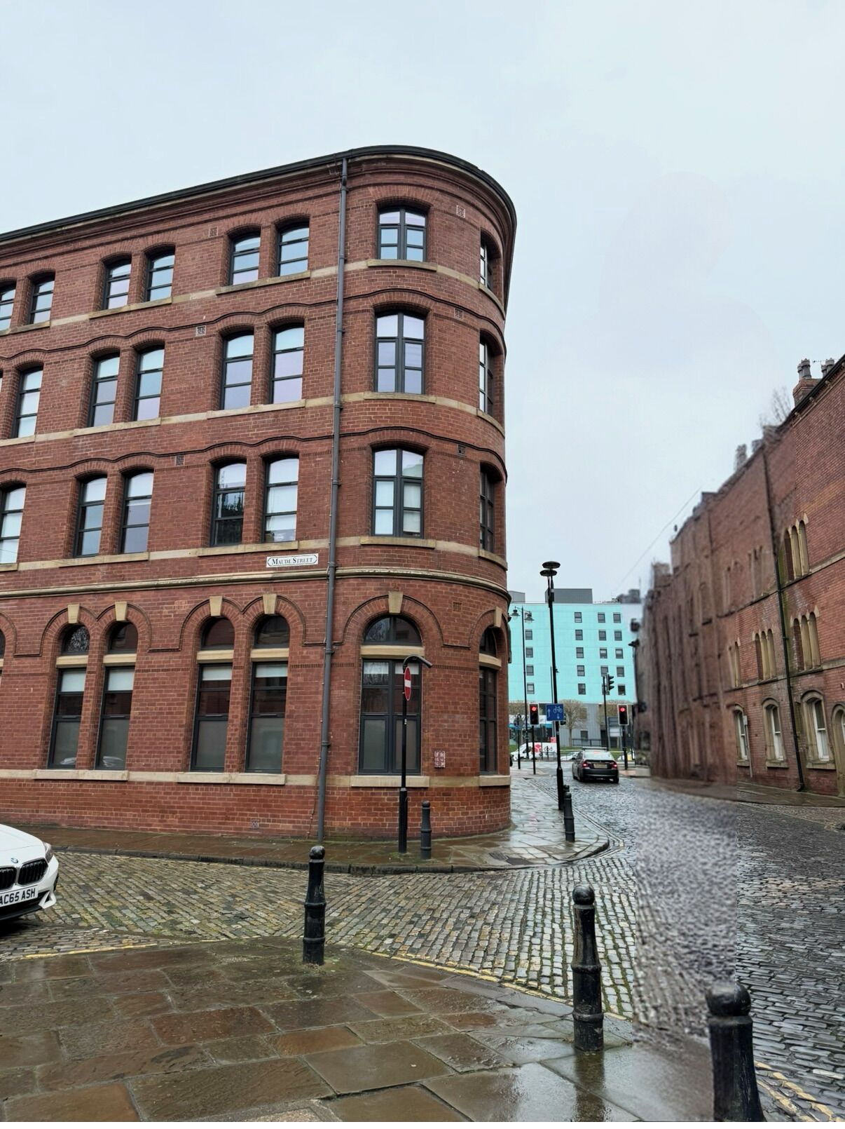 A red brick building with arched windows and a sign reading 'Mule Street.'