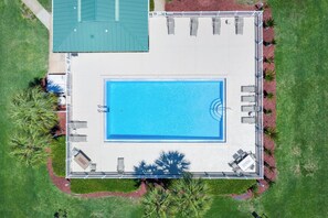 An aerial view of a swimming pool surrounded by a deck with lounge chairs and a covered area with a green roof. - ⭐Walk to Beach | Complex Pool | Sandprints D3⭐ (Miramar Beach)