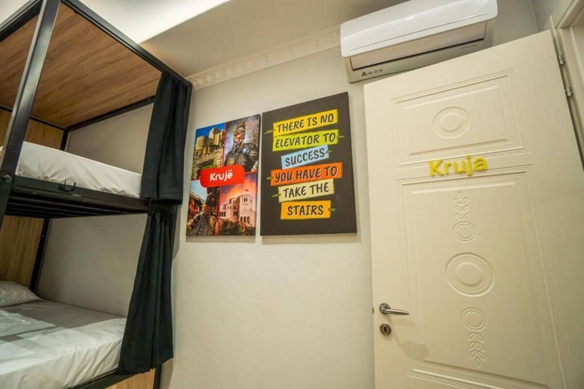 A bunk bed room with a door labeled 'Krueje' and motivational posters on the wall.