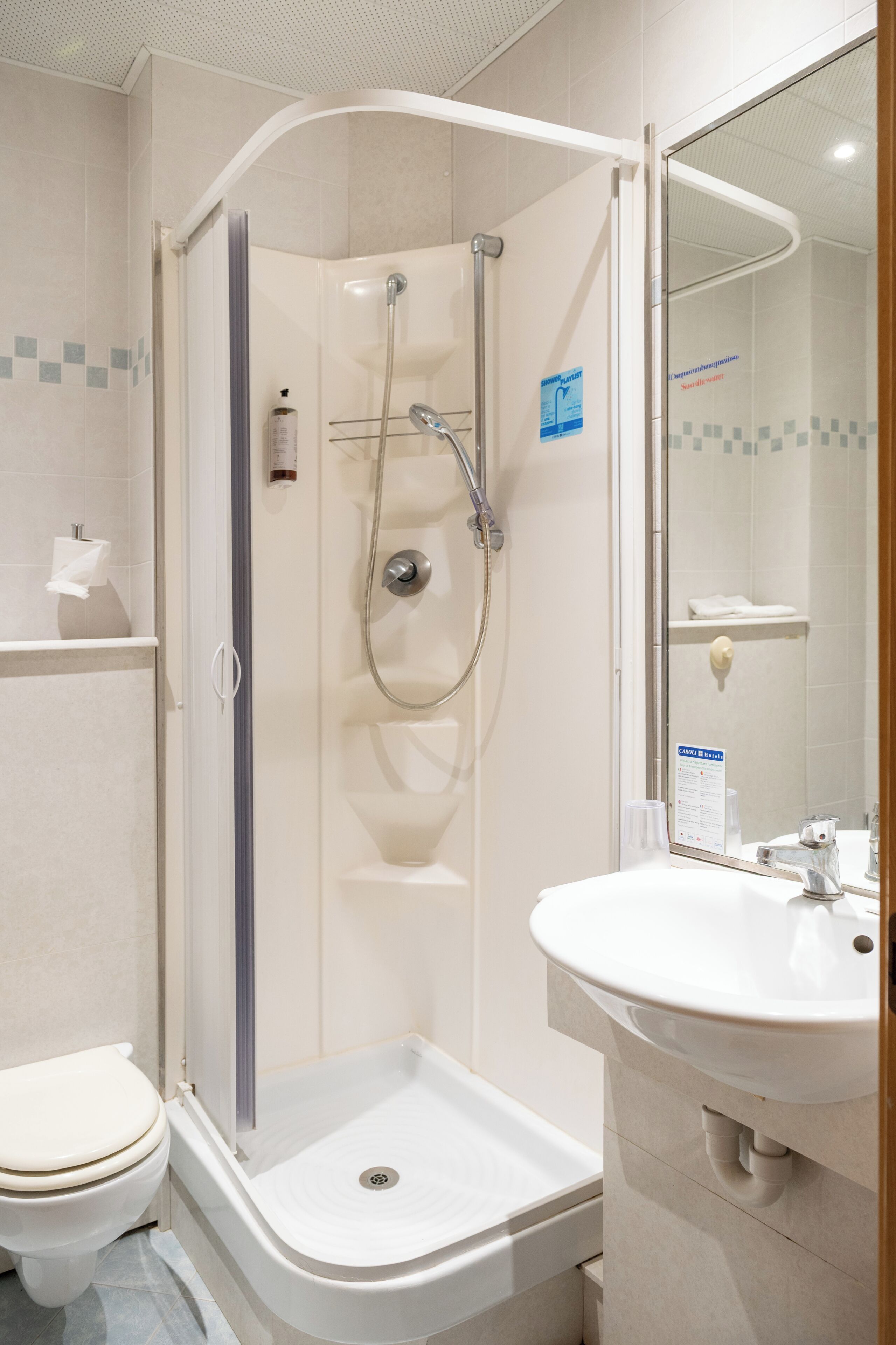 Et moderne badeværelse med brusebad, toilet og vask.